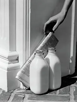 Quarts: Woman's hand reaching down for newspaper propped