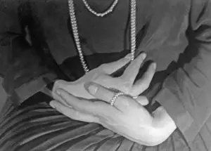 Wanda: Woman's hands with a pearl necklace