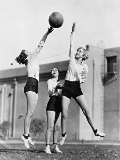 Midair: Three women with basketball in the air