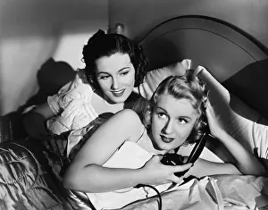 Homosexuality: Two women in bed with telephone