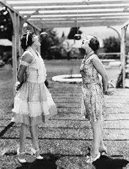 Customary: Women biting apples on strings at Halloween