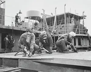 Equal: Three women chippers working in a shipbuilding shipyard