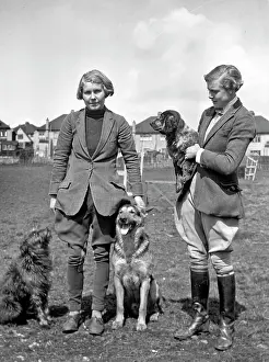 Jodphurs: Two women with three dogs in a field