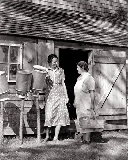 Busybody: Two Women Engaged in Conversation Standing Beside