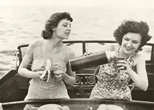 Peeling: Two women having a snack on motorboat