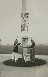 Monmouth: Three women installing a sign advertising a suffrage event