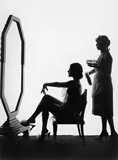 Aiding: Two women in front of a large mirror