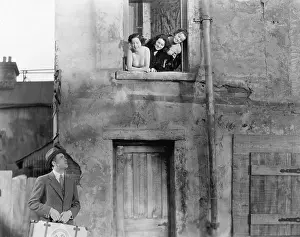 Abode: Three women looking out of a window at a man standing