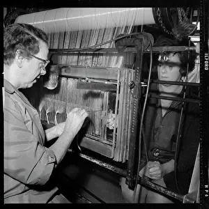 Laborious: Two women passing warp threads through healds (heddles)
