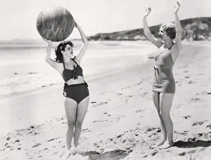 Two Piece: Two women playing ball on the beach