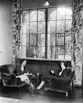 Pane: Two women playing cards and sitting together
