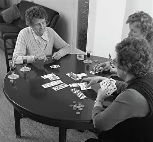 Permed: Three women playing cards at a table