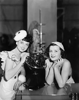 Daydreaming: Two women posing next to a globe