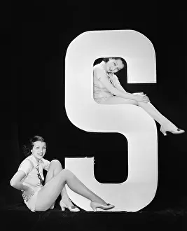 Crouched: Women posing with huge letter S