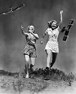 Freeing: Two women running and playing with model airplanes