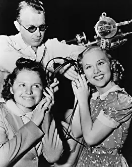 Earphones: Women sharing pair of headphones