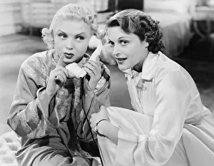 Blonds: Two women sitting together and listening on the