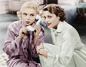 Blonds: Two women sitting together and listening on the