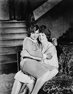 Embraces: Two women sitting together on the other's lap