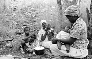 Squatter: Two women, sitting outside cooking over an open