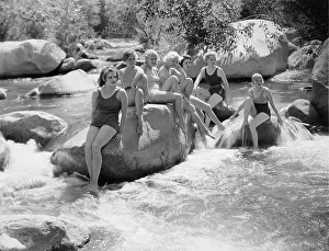 Chilling: Women sitting on rocks in bathing suits