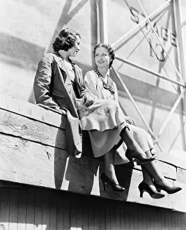 Buddies: Two women sitting together on scaffolding