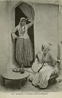 Inhale: Two women smoke from a hookah pipe, Algeria