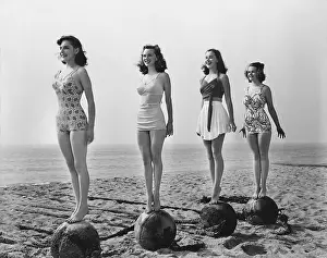 Steadiness: Four women standing on balls at the beach