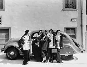 Grouping: Five women standing in front of a car