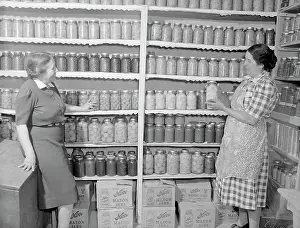 Canning: Two women standing in a kitchen pantry. circa 1946