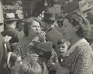 Snacks: Two women, surrounded by children, eating