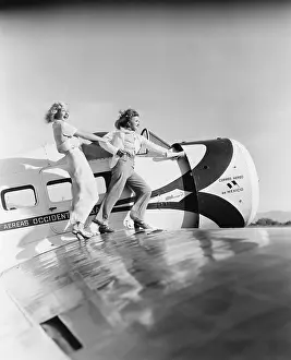 Uncommon: Two women walking on the wing of a plane