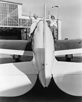 Conformity: Two women waving from the wings of a plane