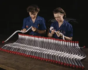 Workbench: Two women workers capping and inspecting tubing
