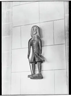 Ambulatory: Wooden figure on the wall above a poor box in the cathedral