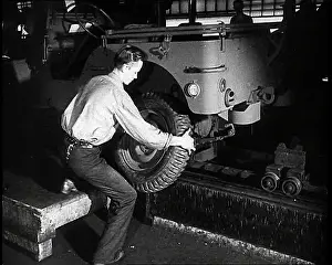 A Worker Fitting Wheels on a Car at an American Factory