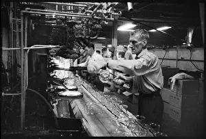 Beakers: A worker handling heated beakers and jars on a