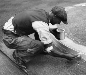 Paints: Worker paints curbstones