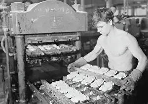 Shirtless: Worker pressing rubber bodies for doll characters, 1936