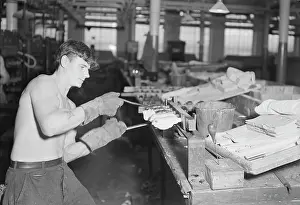 Removing: Worker stripping rubber bodies off core-bars
