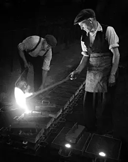 Mould: Workers in foundry pouring molten metal