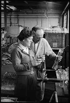 Millfield: Two workers inspecting laboratory glassware in