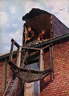 Pane: Two workers lowering a window pane