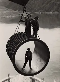Coulee: Four workers riding on a large casing section ?