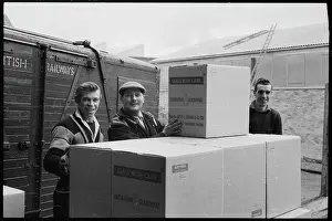 Stacking: Workers stacking boxes of laboratory glassware