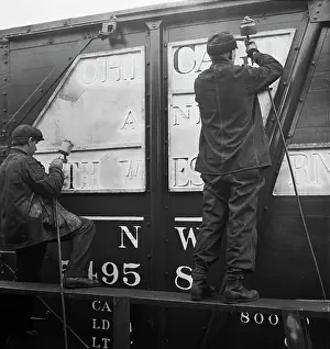 Freight: Workers stenciling the name of the railroad