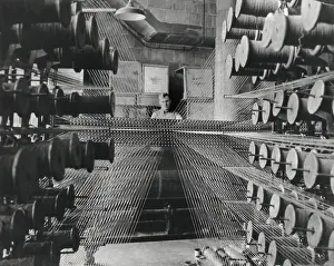 Strung: Workman operating an industrial loom strung with