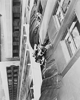 Ledges: Workmen place a canvas over the hole between 78th