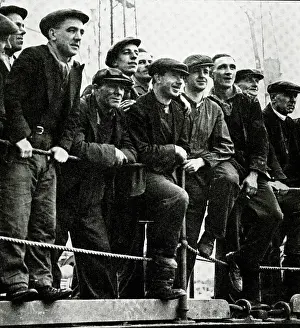 Clyde: Workmen watch RMS Queen Mary on River Clyde