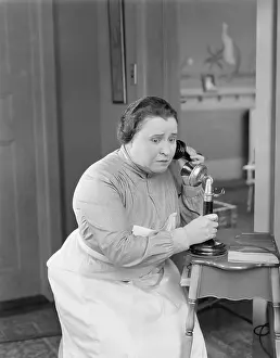 Frown: Worried woman using telephone